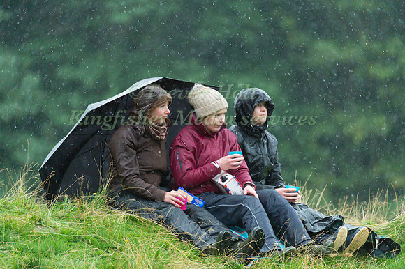 Spectators battle with the wind and  rain
