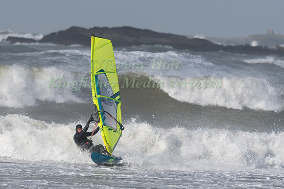A windsurfer riders the waves at Rhosneigr Beach in Angelsey