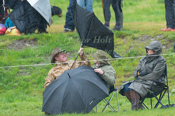 Spectators battle with the wind and  rain