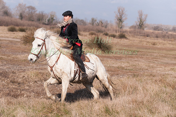 A  rider wearing the distinctive brown and white check scarf of the Camargue takes part in the cross country test at the Camagri
